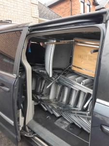 Side view of van with open door, full of chairs